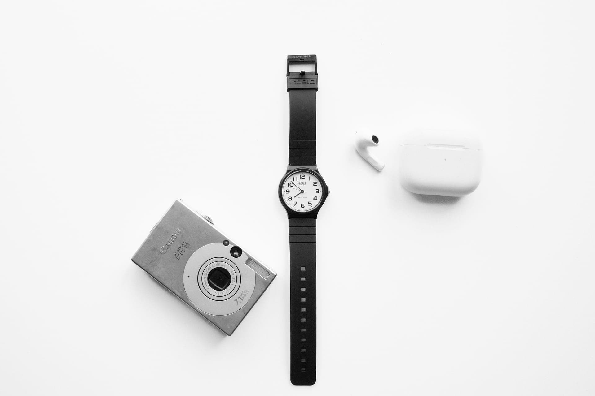 A wristwatch and a few calm objects arranged on pale stone