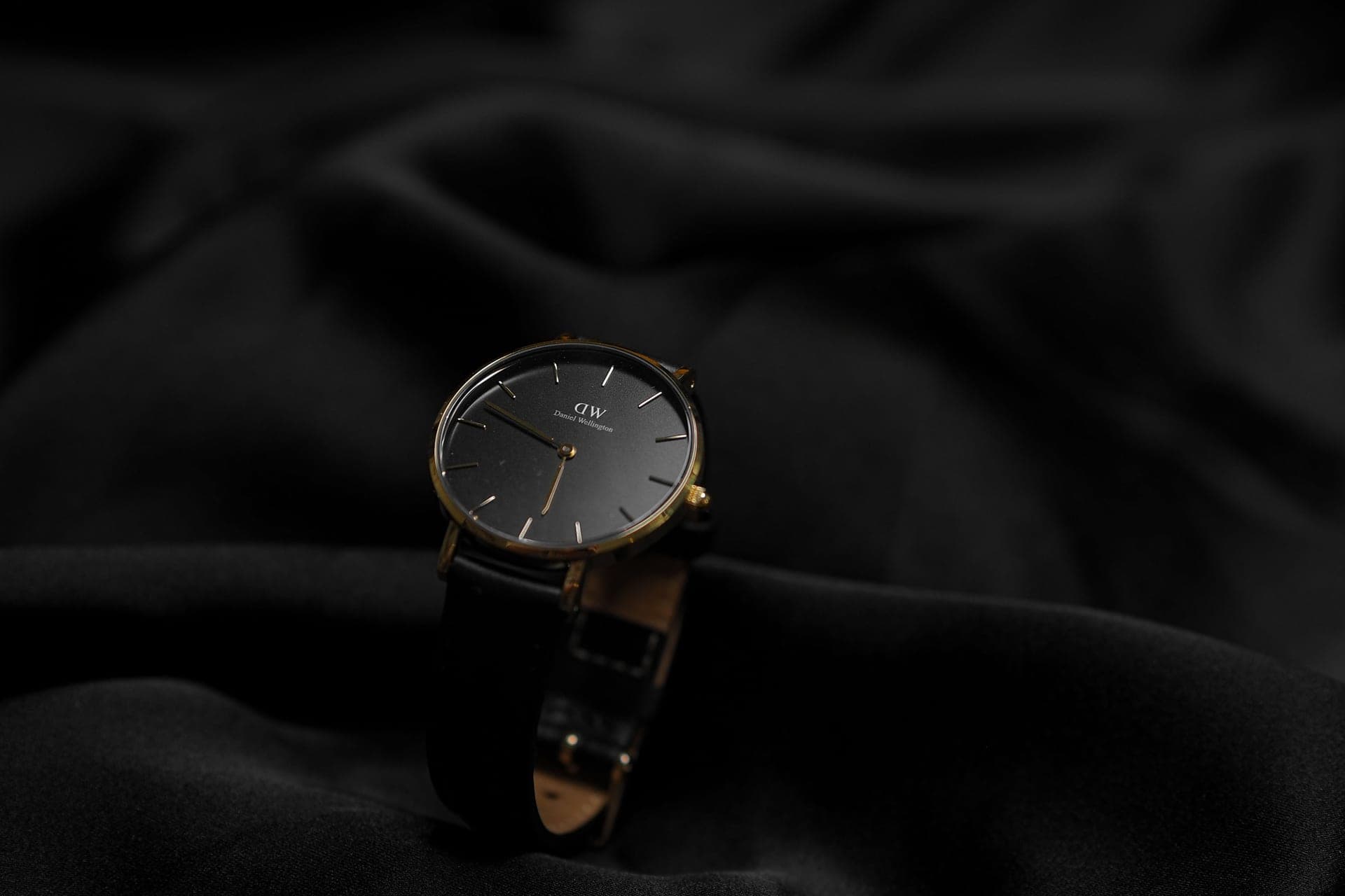 A wristwatch resting on pale linen in soft daylight